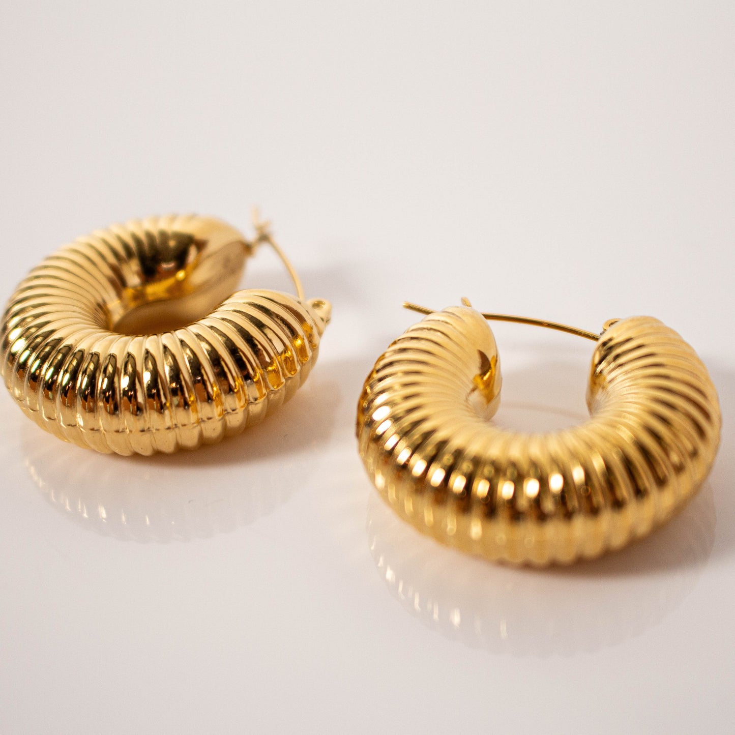 Aururum Ohrringe auf einer weißen Fläche